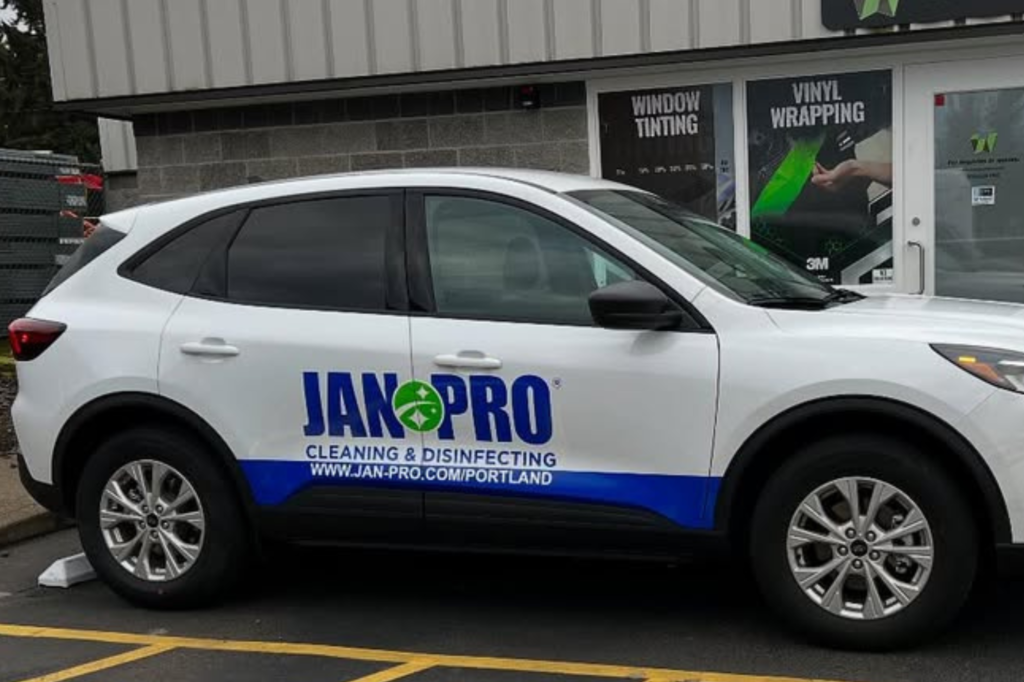 A JanPro-branded car featuring an eye-catching wrap, designed to attract attention and promote the company's services.